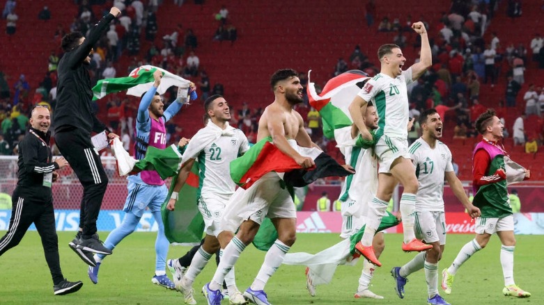 لاعبو الجزائر يرفعون العلم الوطني احتفالاً بفوزهم خلال مباراة ربع نهائي كأس العرب لكرة القدم 2021 بين المغرب والجزائر على ملعب الثمامة بالعاصمة القطرية الدوحة، 11 ديسمبر/ كانون الأول 2021- الصور لفرانس 24